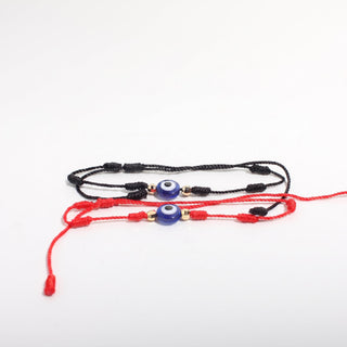 Red and Black Evil Eye Bracelet Adjustable Cord 2 Pack, angled view of both the red-cord and black-cord bracelets with blue evil-eye beads and gold accents, photographed on a clean white background. Stonebridge Imports.