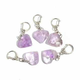 Amethyst Heart Charm - Pack of 5 - five polished pale lilac amethyst hearts, each on its own silver-tone swivel clasp, arranged on a clean white background. Stonebridge Imports.