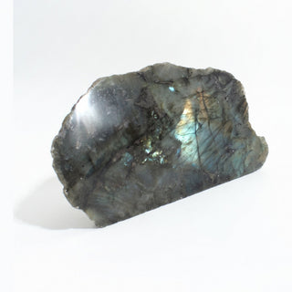Labradorite Polished Face Cut Base Unique #1 seen from an angle, showing the gold and teal flash on the polished face and the flat sawn base, on a clean white background. Stonebridge Imports.