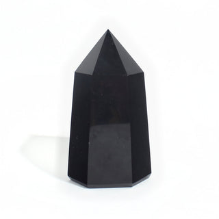 Black Obsidian Generator Unique #12 — polished six-sided tower rising to a faceted point, glossy jet-black faces, photographed on a clean white background. Stonebridge Imports.