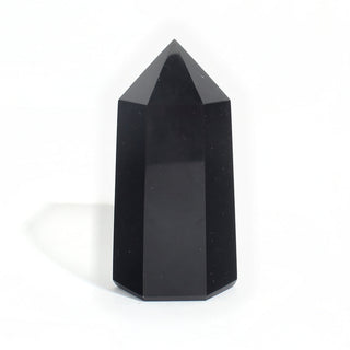 Black Obsidian Generator Unique #13 — polished six-sided tower rising to a faceted point, glossy jet-black faces, photographed on a clean white background. Stonebridge Imports.