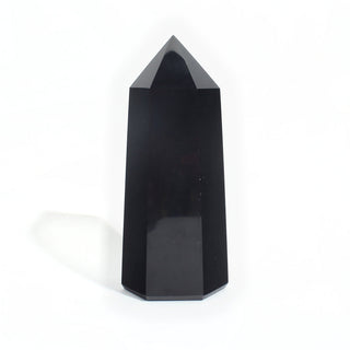 Black Obsidian Generator Unique #15 — polished six-sided tower rising to a faceted point, glossy jet-black faces, photographed on a clean white background. Stonebridge Imports.