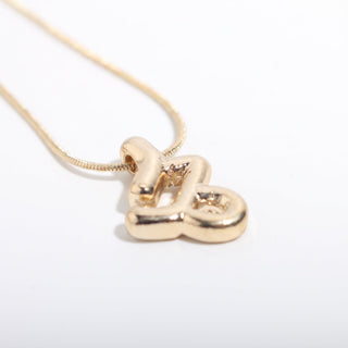 Capricorn — Gold Plated Zodiac Necklace, showing the puffy 3D gold Capricorn glyph pendant on a fine gold snake chain, photographed on a clean white background. Stonebridge Imports.