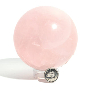 Rose Quartz Sphere Unique #192 beside a Canadian dime for scale, showing the 3 inch pale pink sphere on its clear stand, on a clean white background. Stonebridge Imports.