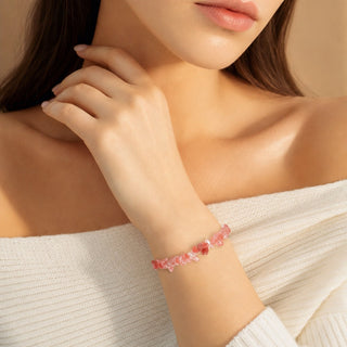 Cherry Quartz bead bracelet worn with the fingertips resting at the collarbone