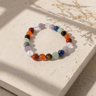 Seven Chakra bead bracelet resting on a stone slab