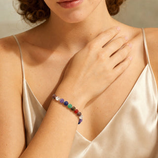Seven Chakra bead bracelet worn with the hand resting on the chest