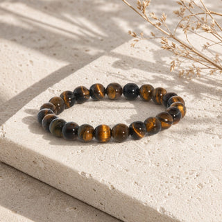 Gold Tiger's Eye bead bracelet resting on a stone slab