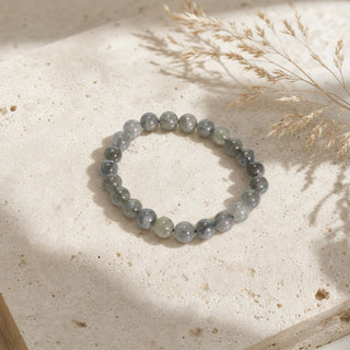 Labradorite bead bracelet resting on a stone slab