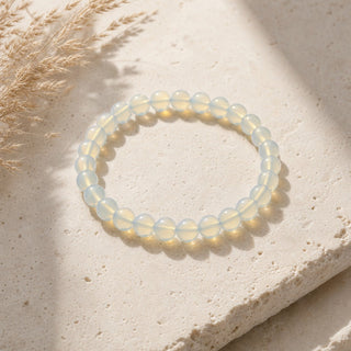 Opalite bead bracelet resting on a stone slab
