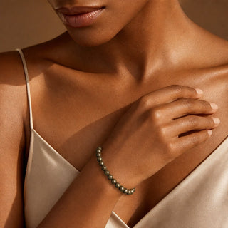 Pyrite bead bracelet worn with the hand resting on the chest