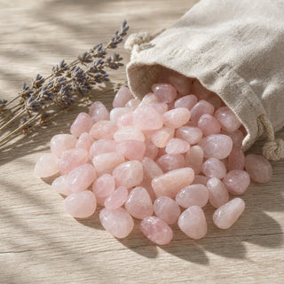 Rose Quartz B Tumbled Stones spilling from a linen pouch