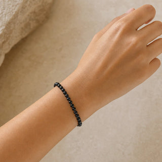 Shungite bead bracelet worn on the wrist, close-up