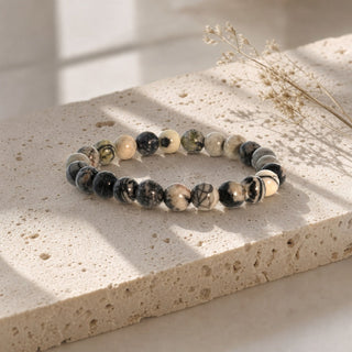 Silk Stone bead bracelet resting on a stone slab