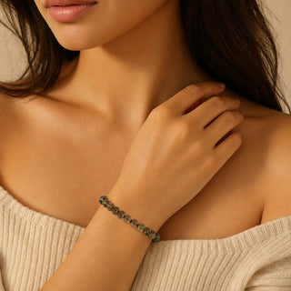 Smoky Quartz bead bracelet worn with the fingertips resting at the collarbone