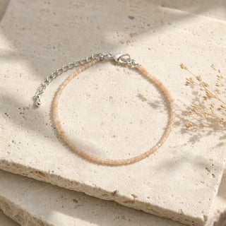 Sunstone bead bracelet resting on a stone slab