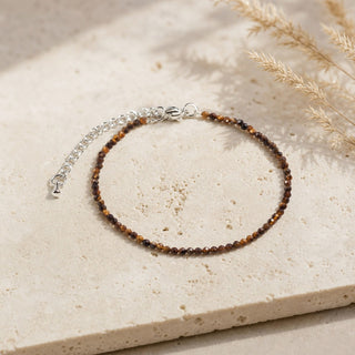 Tiger's Eye bead bracelet resting on a stone slab