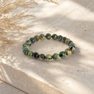 African Turquoise bead bracelet resting on a stone slab